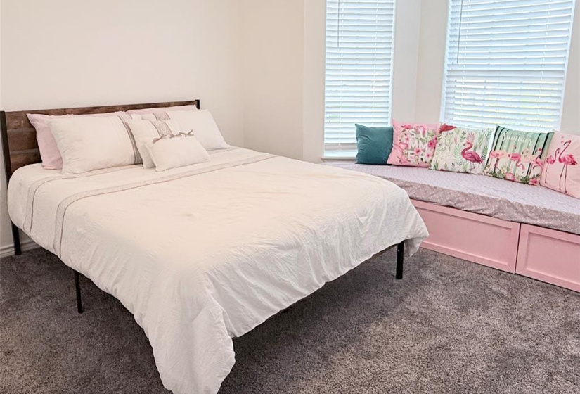 This bedroom offers a large bay window with pool view and waterfront view, large built in seating and storage with custom cushions perfect for reading by the window.