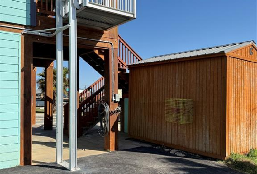 This photo shows the exterior of the home and the cargo lift system. This is the business side of the house with ample storage, RV hook ups and convenient loading.