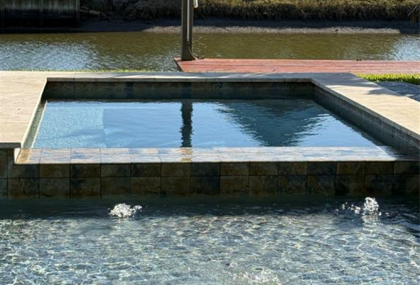 Luxurious heated pool and spa overlooking the canal with three flowing fountains and a 