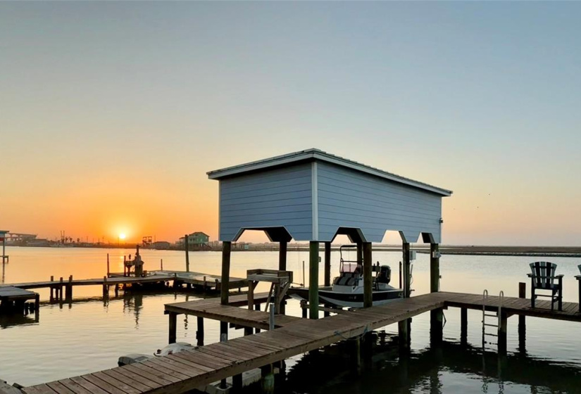 Waterfront view at sunset over your pier and boatlift for enjoying peaceful evenings by the water.