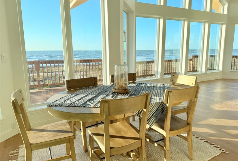 Dining area with large windows offering stunning Gulf view and ample natural light.