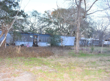 Cleared with some nice big trees, mobile home has no value and neither does shed next to it.