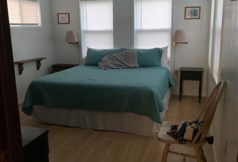 The primary bedroom features large windows and a ceiling fan.