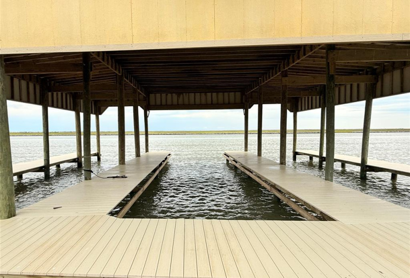 This photo showcases a waterfront property featuring a sturdy boat dock with an upper deck and stairs, ideal for enjoying scenic views and easy water access.