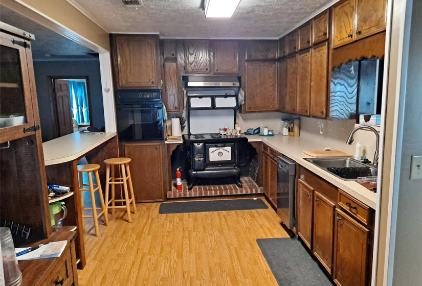 KITCHEN WITH BREAKFAT FAR, ANTIQUE TYPE STOVE, DISHWASHER AND BUILT IN OVEN.