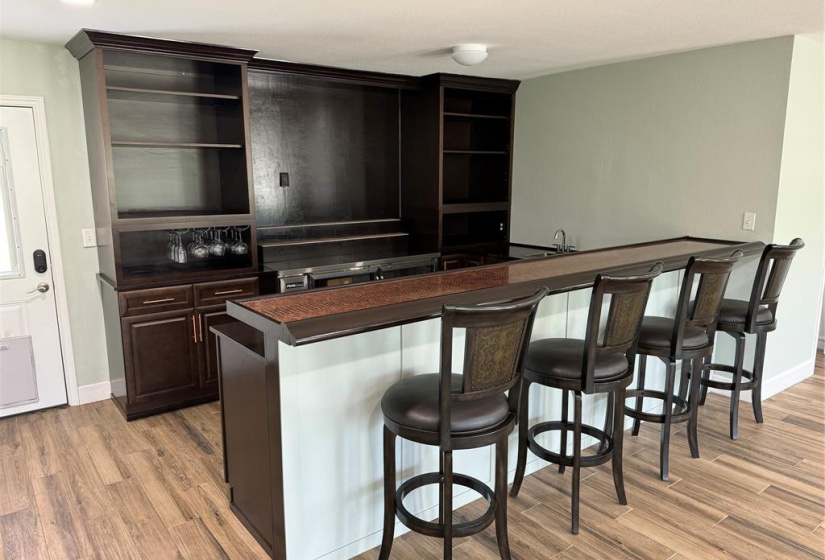 Custom built bar area with room on the back wall for a large TV. Note the large beverage cooler on the back wall so you don't need to walk to the kitchen for drinks or refrigerated items.