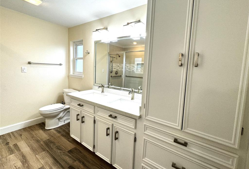 Walking into the spacious master bath, you'll notice the large storage/linen cabinet, quartz countertop with double sinks and another bidet toilet. Not seen in this pic are a storage/linen closet on the left and a walk-in closet on the right, directly behind the photographer in this angle. Tons of storage space!