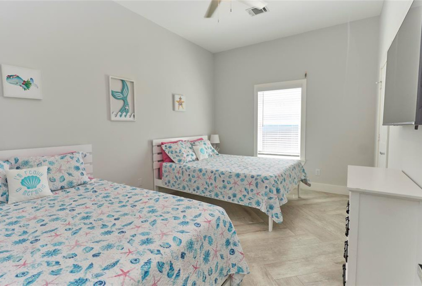 Second bedroom features a large window and beautiful flooring.