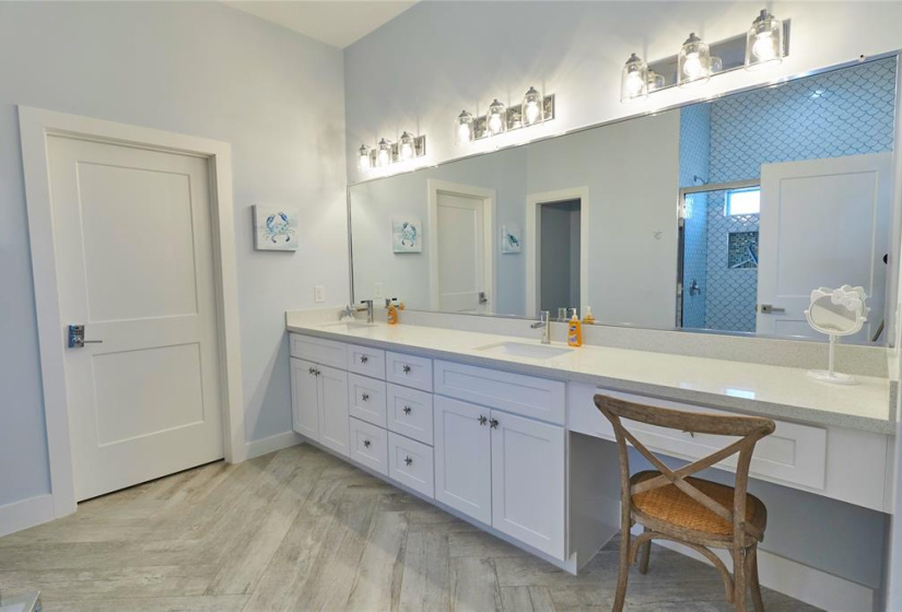 Second bathroom features double sinks, vanity area, and white cabinets.