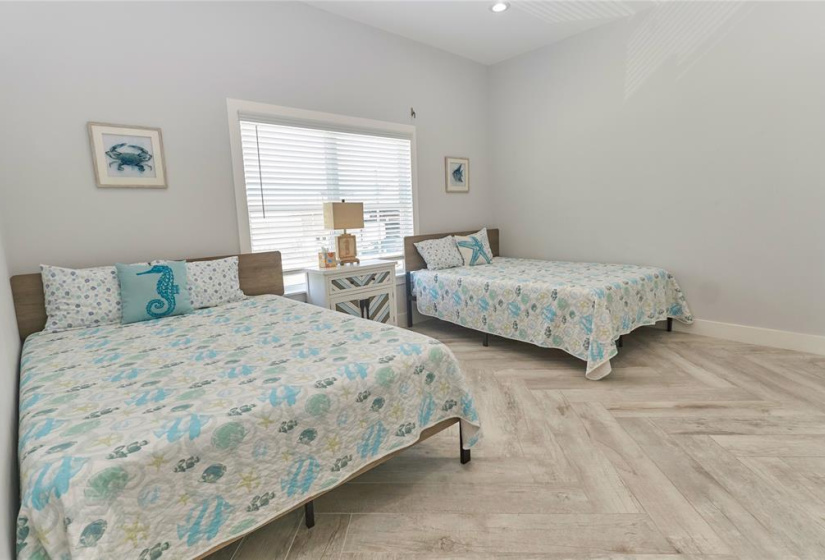 Third bedroom features a large window and beautiful flooring.
