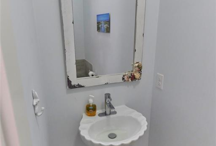 Half bathroom features a modern pedestal sink.