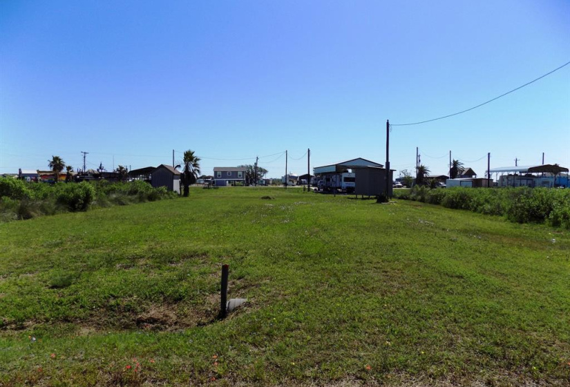This is the Flamingo St. side on the property.  The lot to the left is mowed the lot to the right still needs cleared.  There was a RV years ago on this side of the property.  Water is at the lot and you will need to bring in a sewer connection.  The old electric pole is still here and will need updating.